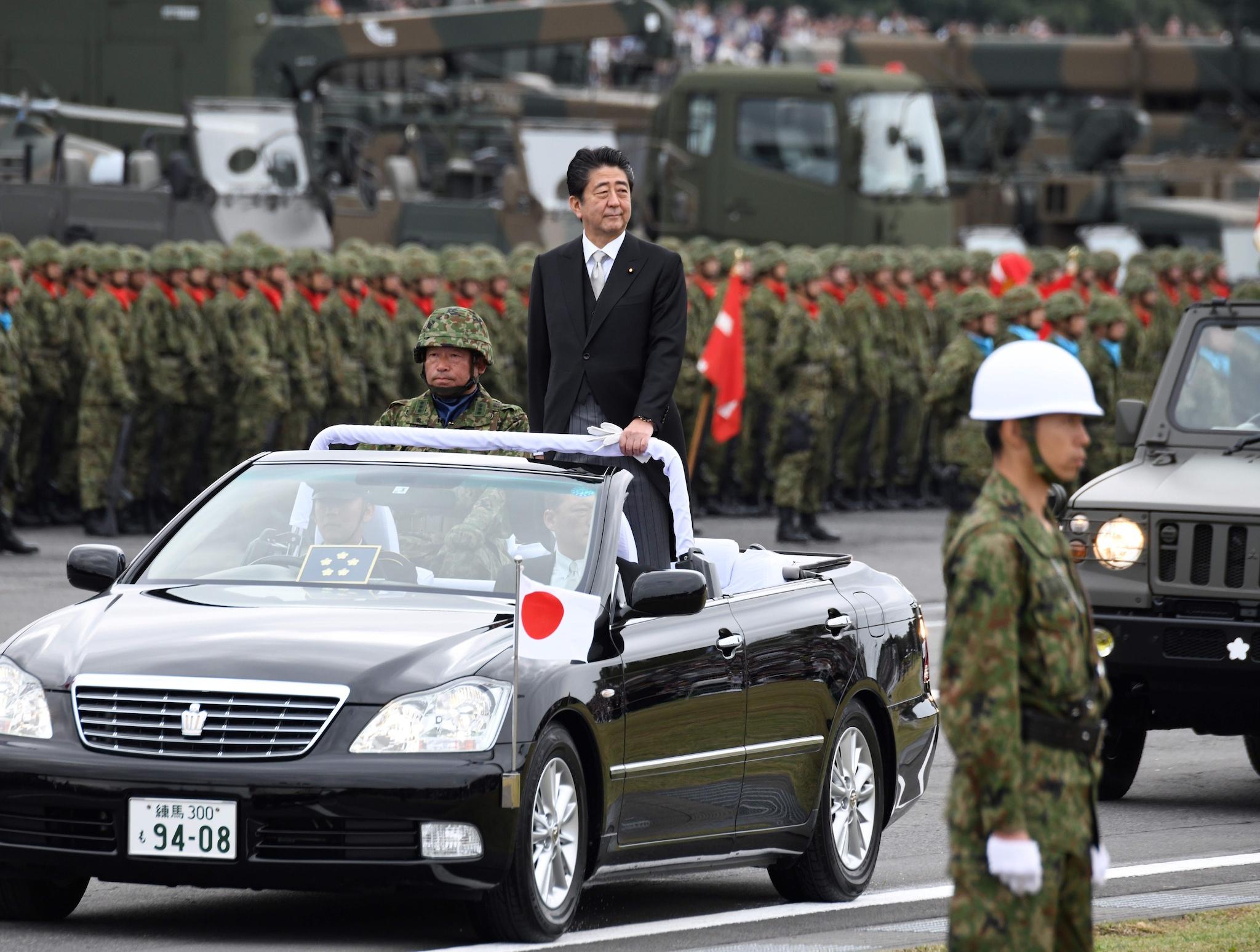 Japanese Prime Minister Shinzo Abe (C) inspects Self-Defence Force soldiers in Asaka