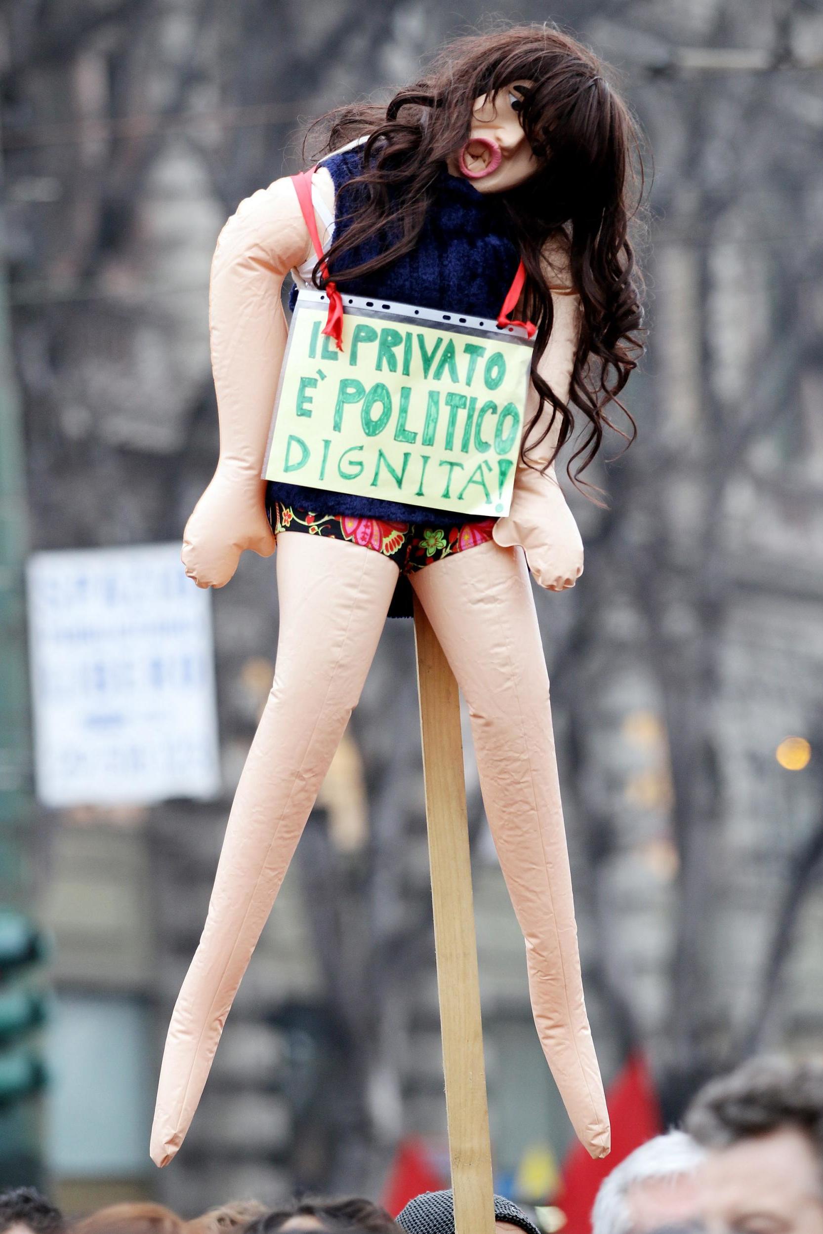 A protester holds a sex doll during a demonstration to appeal for greater dignity for Italian women in Milan (Getty)
