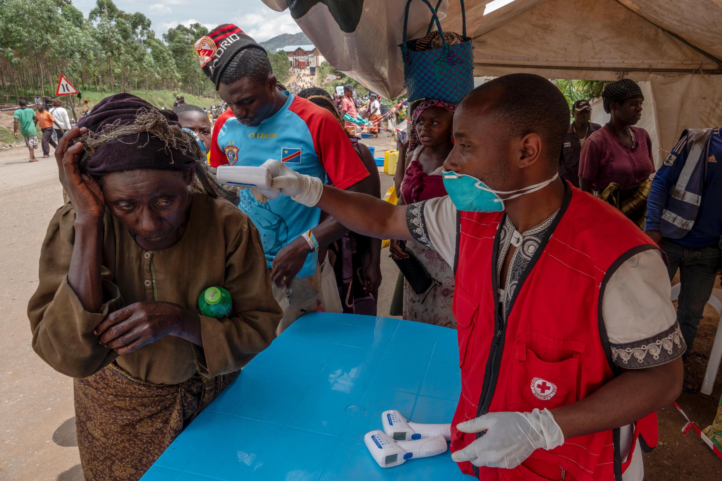 Red Cross workers take the temperature of people crossing the border from Congo into Uganda (The Washington Post)