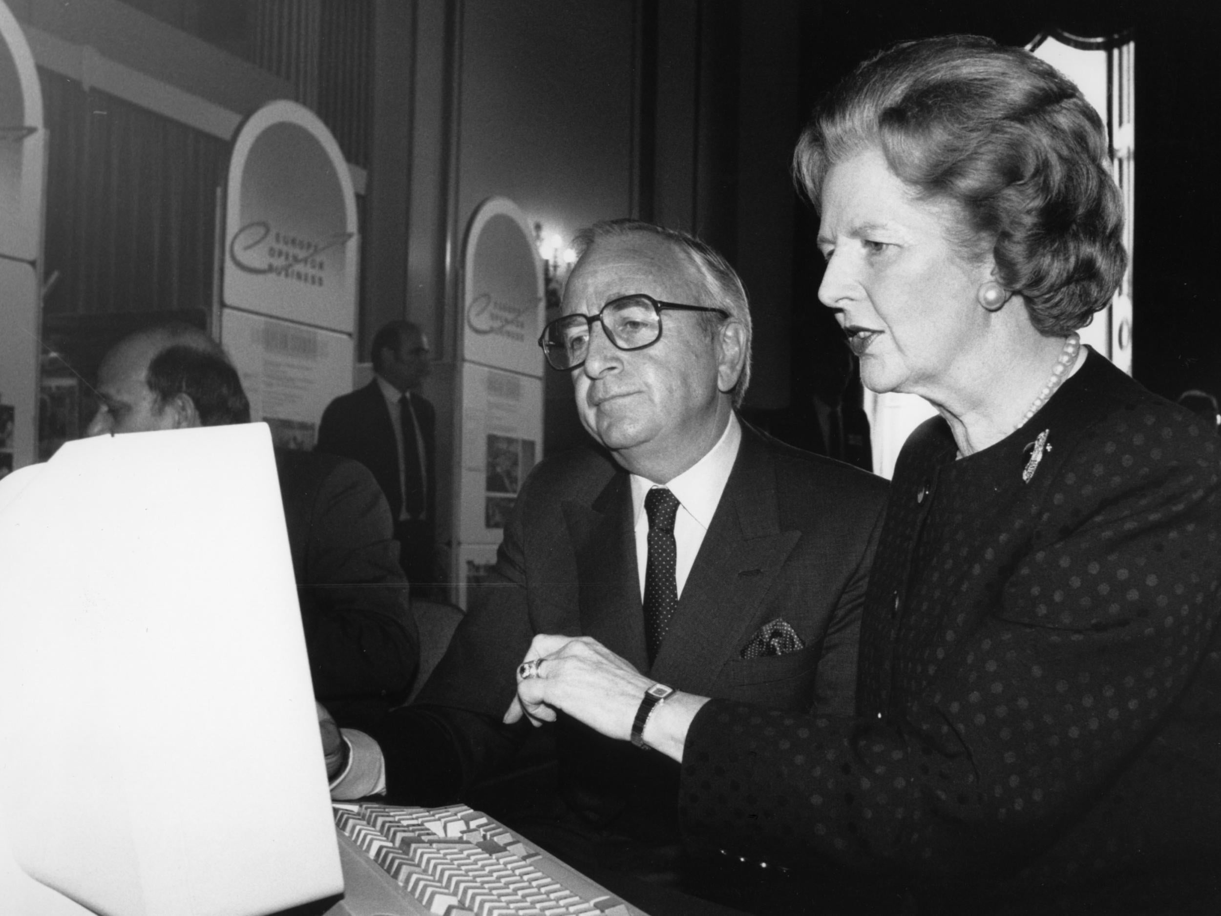 Trade and industry secretary Lord Young and Margaret Thatcher study information on a computer of a single European trade market at Lancaster House in London
