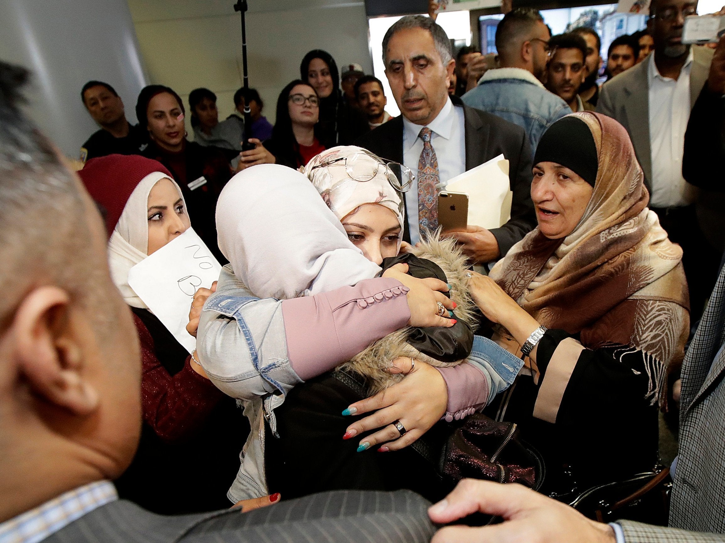 Shaima Swileh (centre with her back turned) is greeted by supporters after arriving at San Francisco International Airport