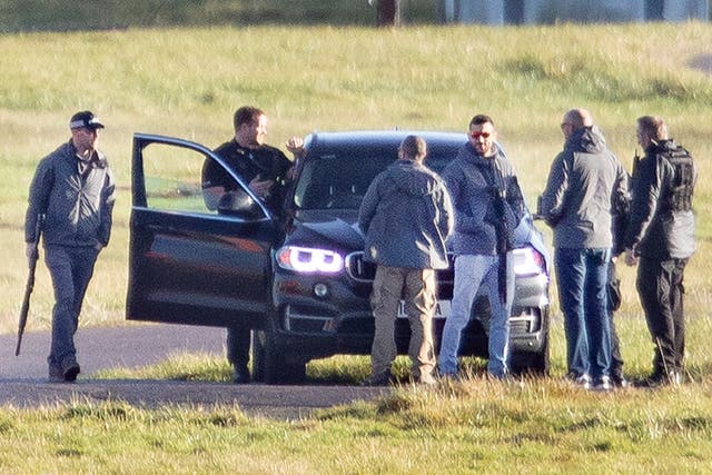 Armed police are seen next to the runway at Gatwick Airport taking part in the hunt for the drone operator