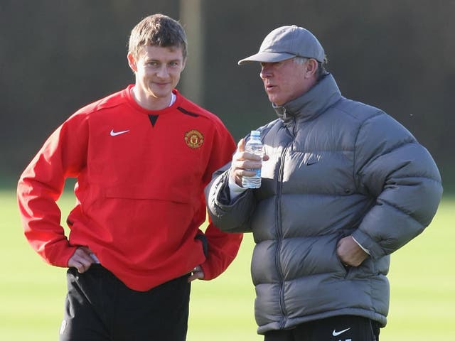 Ole Gunnar Solskjaer chats with manager Sir Alex Ferguson