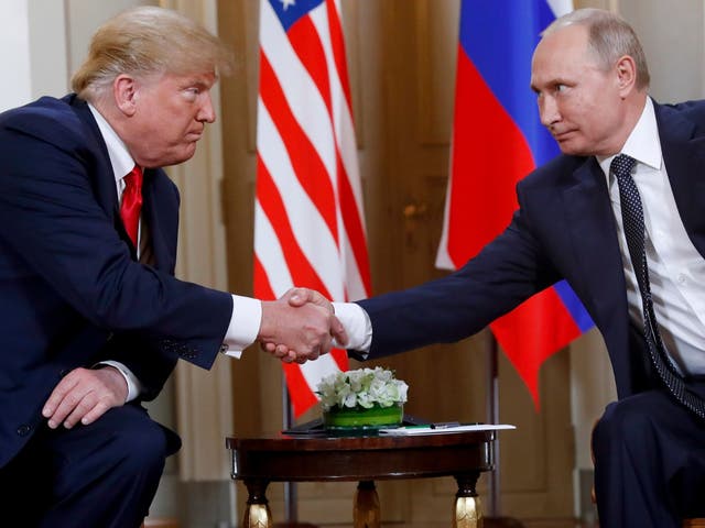 US President Donald Trump, left, and Russian President Vladimir Putin shake hands at the beginning of a meeting at the Presidential Palace in Helsinki