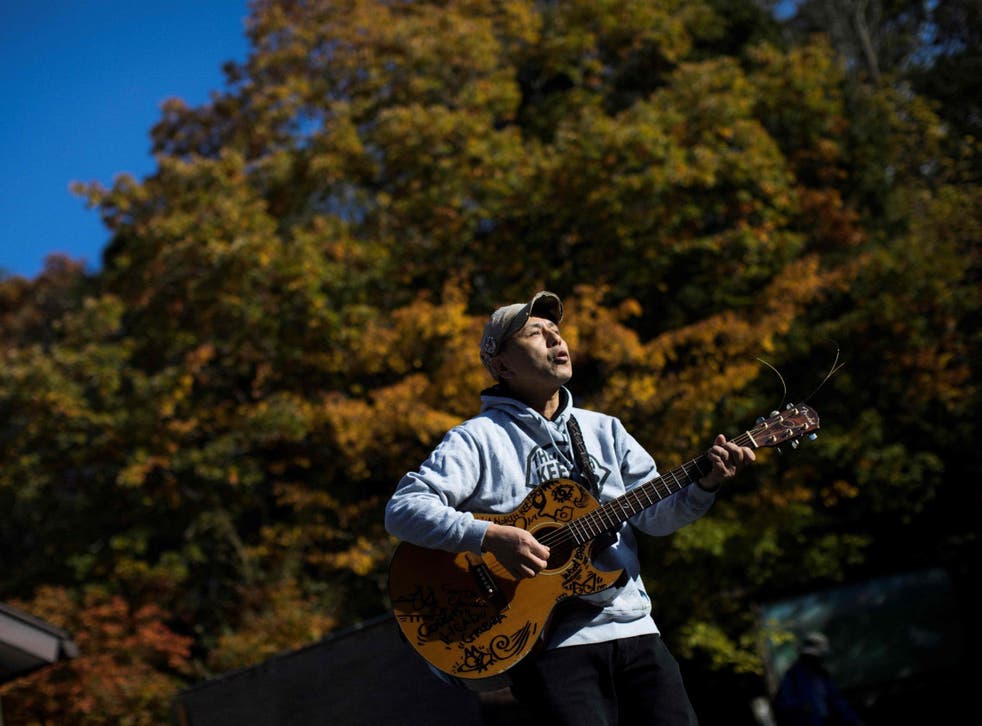 Kyochi Watanabe plays music into Aokigahara forest in the hope of lifting suicidal people out of despair