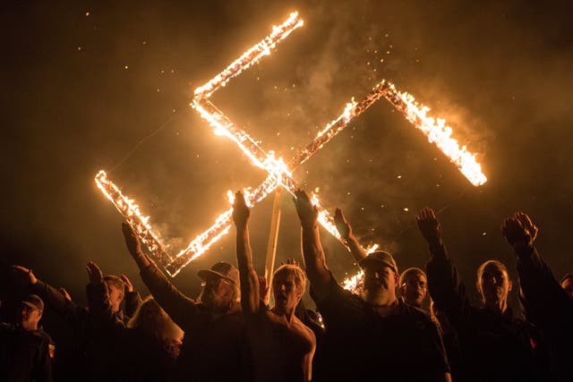 Supporters of the National Socialist Movement, a white nationalist political group, give Nazi salutes while burning a swastika in Georgia, US