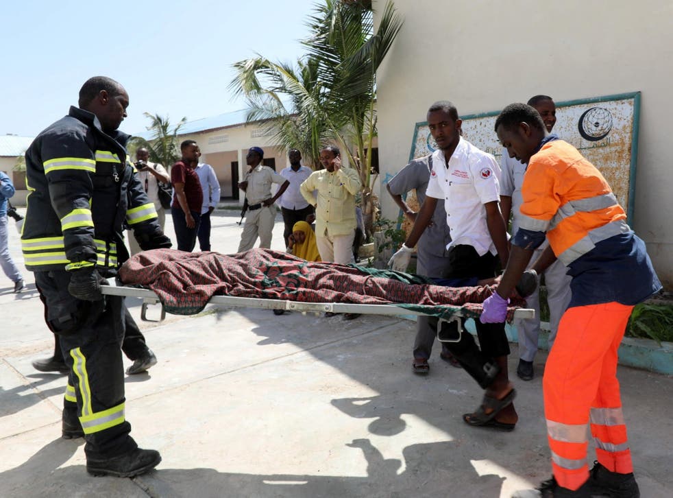 Rescuers carry a body from the scene of one of yesterday’s blasts