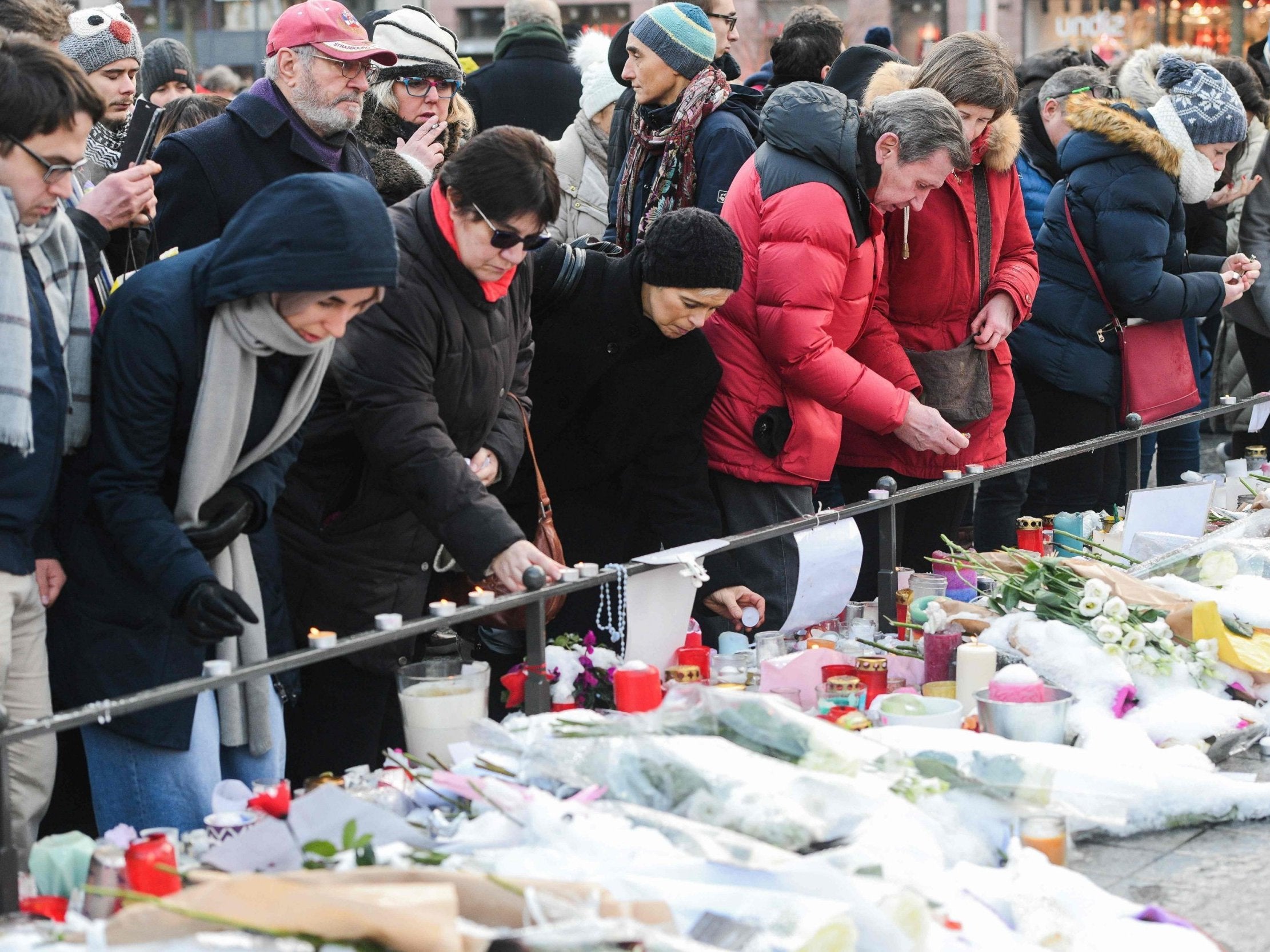People light candles and lay floral tributes during a gathering around a makeshift memorial at Place Kleber, Strasbourg, on 16 December (AFP/Getty)