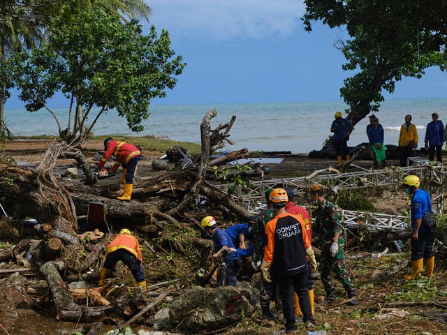 Rescue workers clear debris left by a by a tsunami at a resort hotel on 24 December, 2018 in Tanjung Lesung, Indonesia