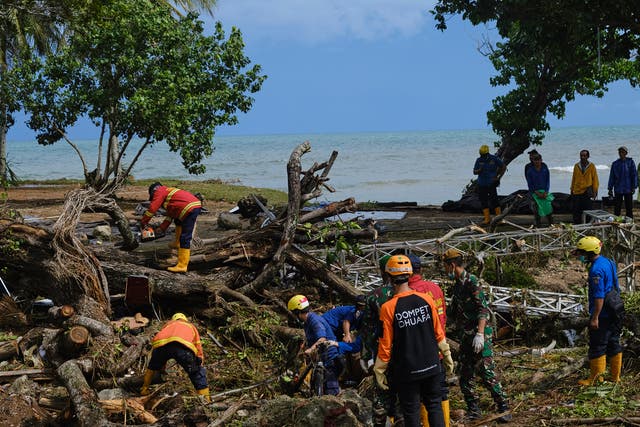 Rescue workers clear debris left by a by a tsunami at a resort hotel on 24 December, 2018 in Tanjung Lesung, Indonesia