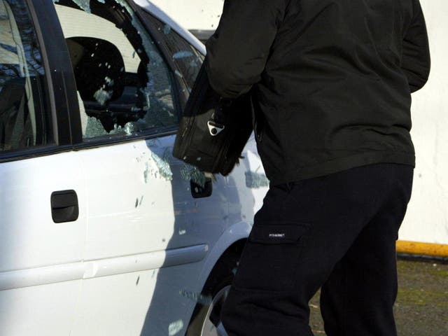 <p>Thief breaking into a car</p>