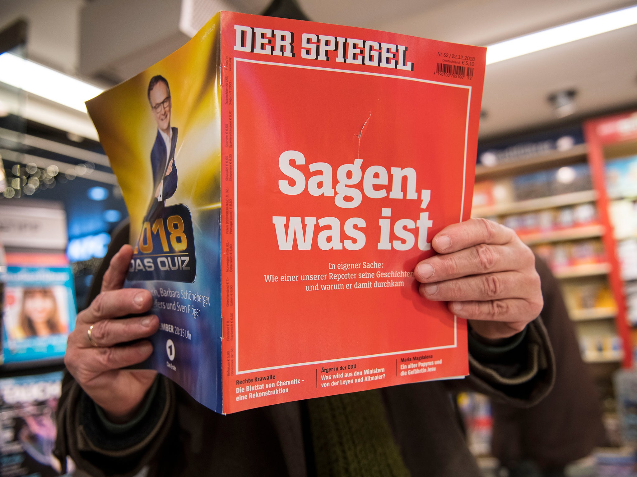 A man looks into the latest issue of German newsweekly Der Spiegel with a cover page that reads: 'To say, what is', a quote referring to the credo of Rudolf Augstein, founder of the magazine, in an issue devoted to a scandal surrounding Claas Relotius