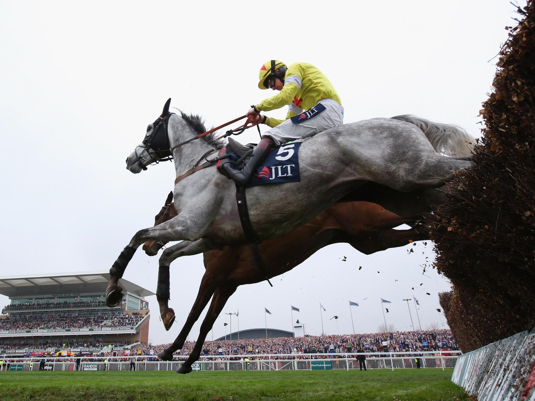 Politologue clears the last fence during the JLT Melling Chase on Ladies Day at Aintree