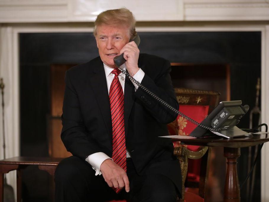 US President Donald Trump takes phone calls from children in the East Room of the White House December 24, 2018 in Washington, DC