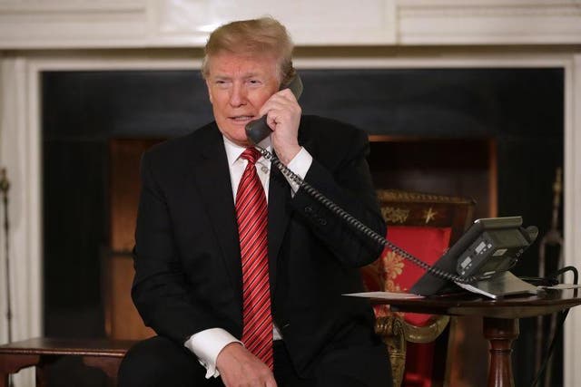 US President Donald Trump takes phone calls from children in the East Room of the White House December 24, 2018 in Washington, DC