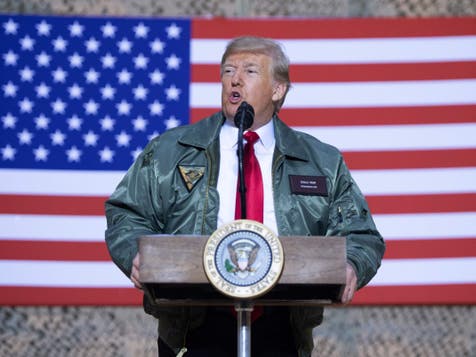 <p>Donald Trump speaks to members of the US military during an unannounced trip to the Al Asad Air Base in Iraq, December 26, 2018</p>
