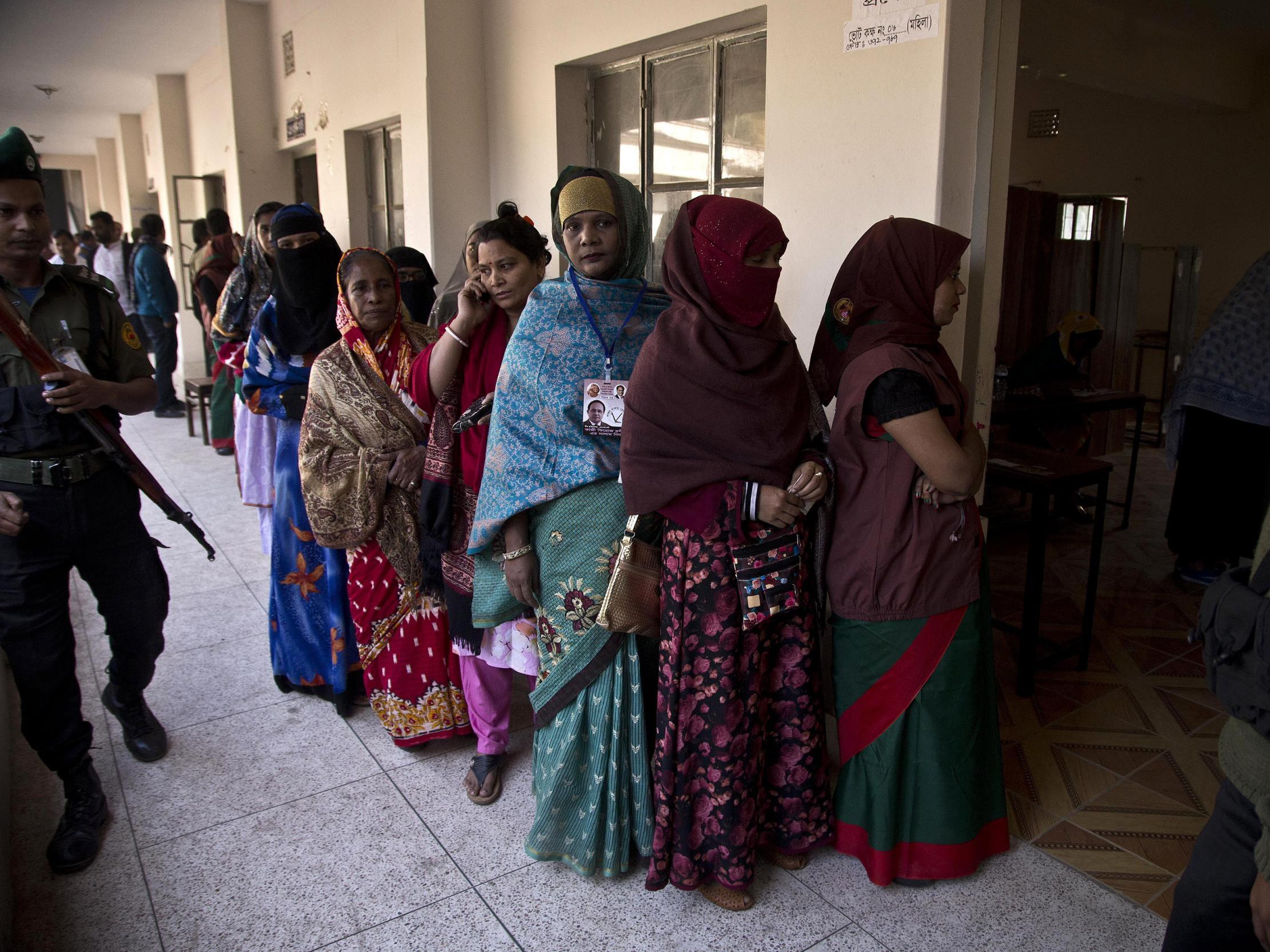 Women queue up outside a polling station in Dhaka to cast their votes