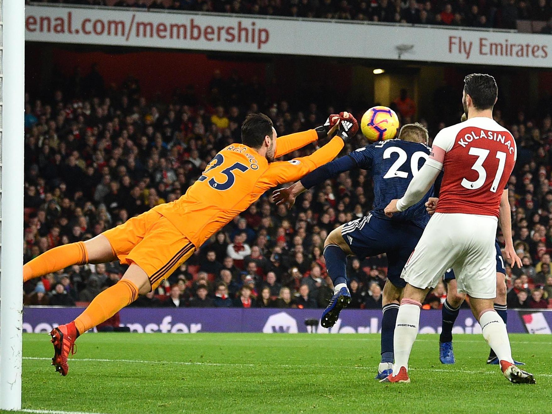 Sergio Rico dives to punch clear an Arsenal cross