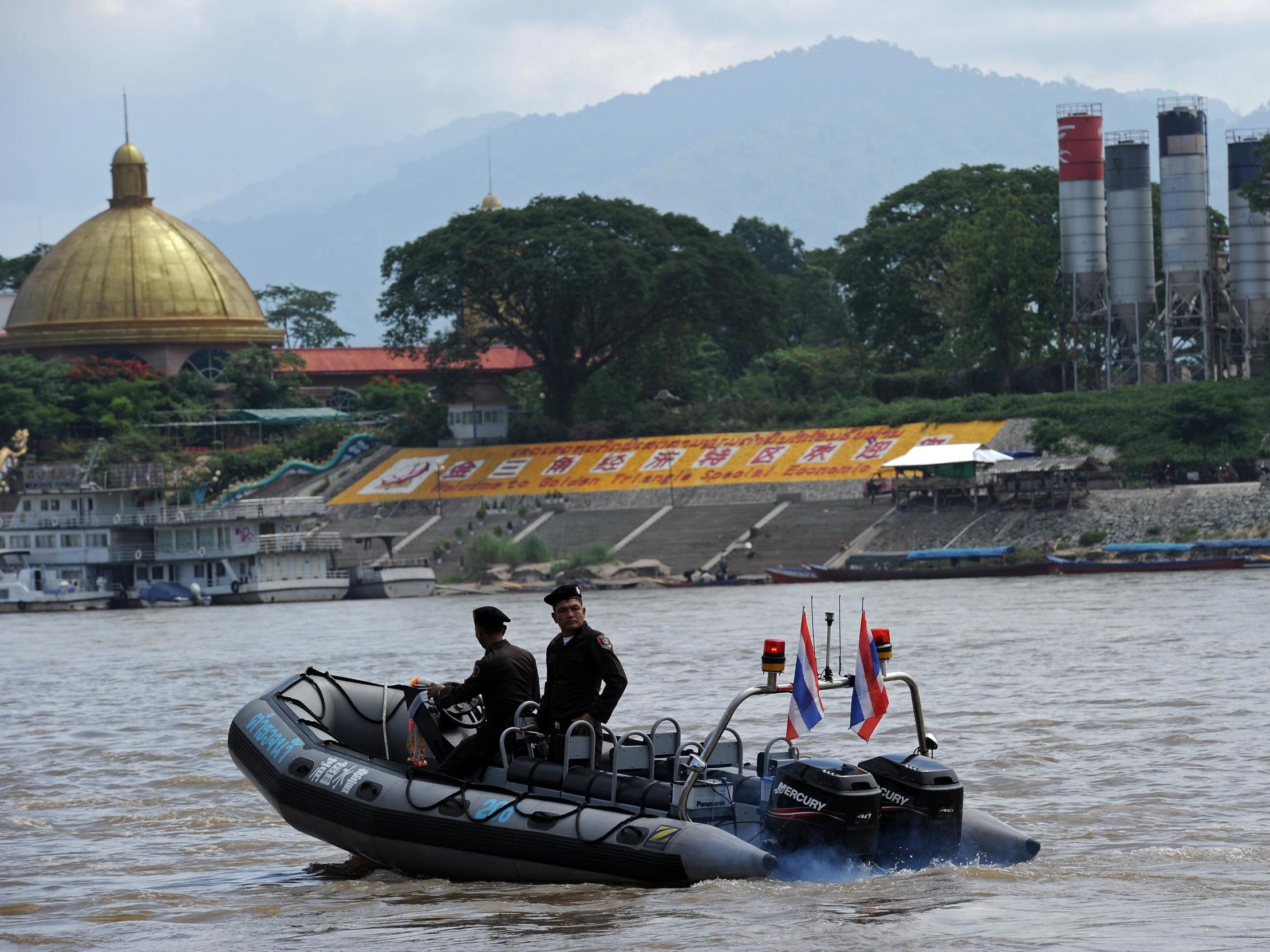 Thai police patrol the Mekong river, where the bodies of two men were found stuffed with concrete