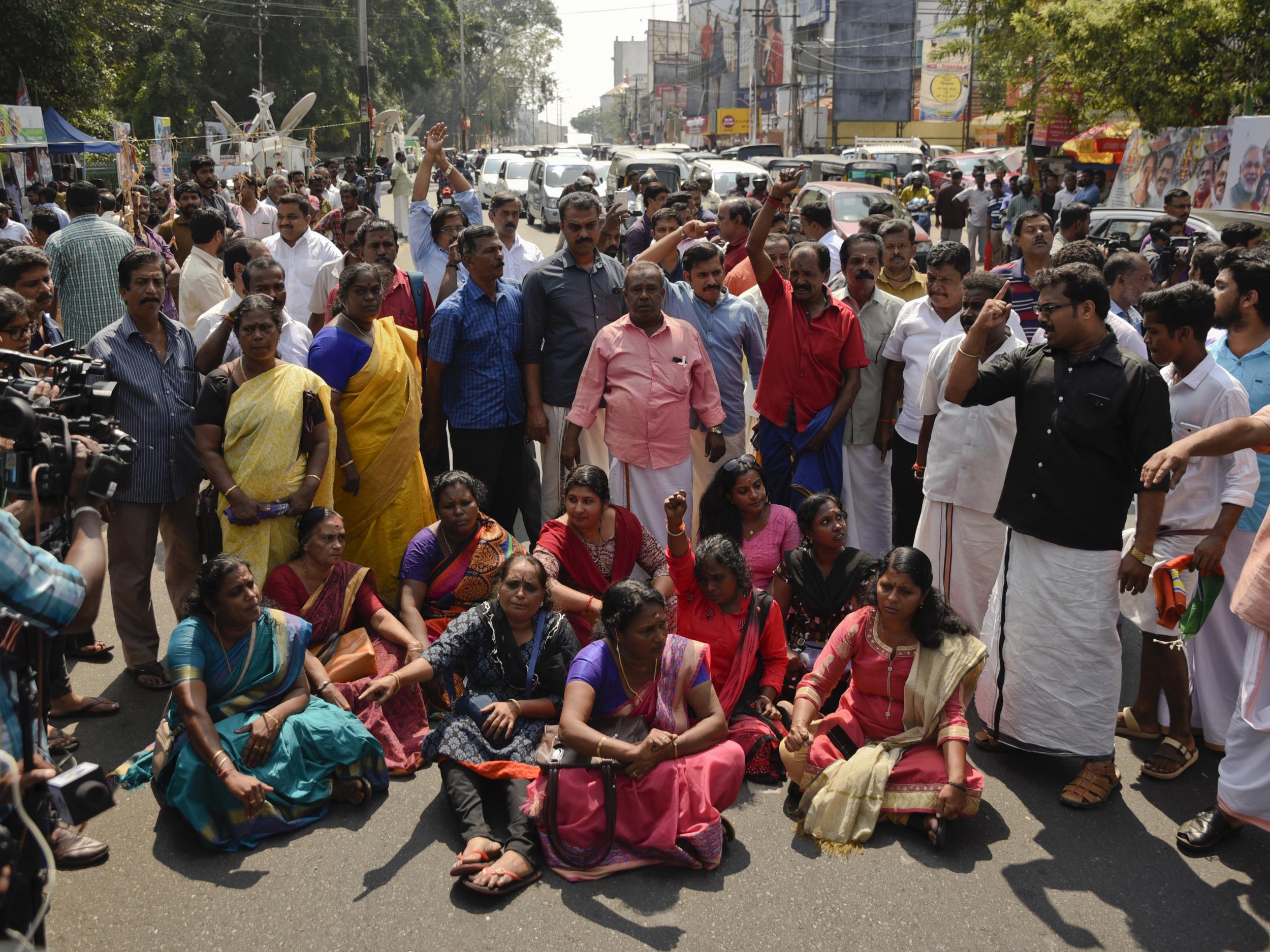 Protestors block traffic and shout slogans after hearing reports of the two women entering the Sabarimala temple
