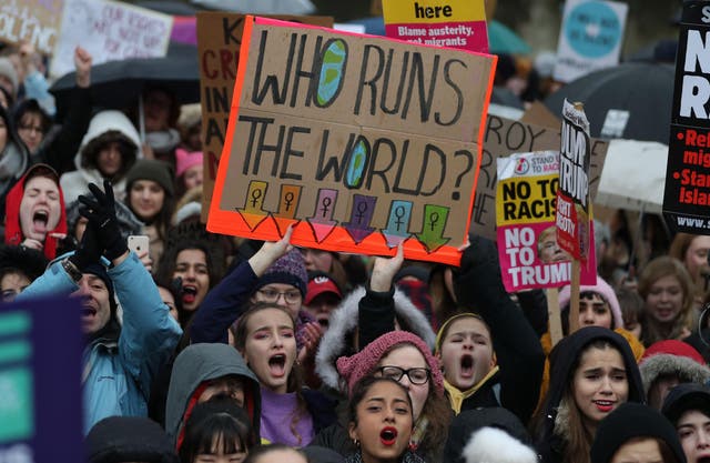 Protesters hold up placards during the Women's March in London on 21 January 2018 as part of a global day of protests