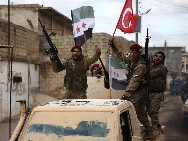 Turkish-backed Syrian fighters raise Turkish and opposition flags in the north of Aleppo province before heading to the Kurdish-controlled town of Manbij on 29 December