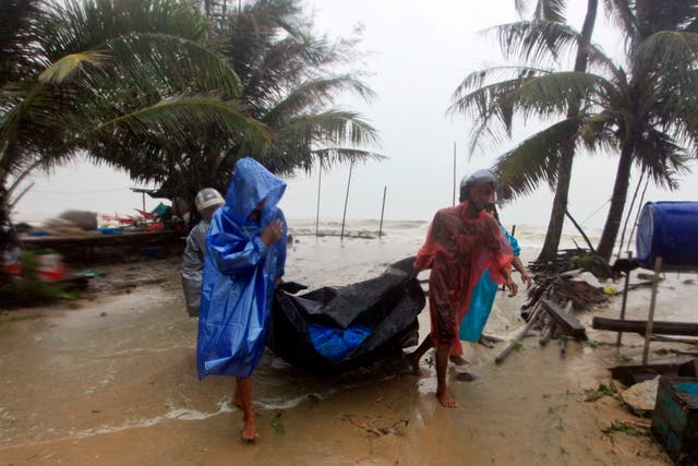 Thai locals clear the shoreline as Tropical Storm Pabuk makes landfall in Pak Phanang in the southern province of Nakhon Si Thammarat