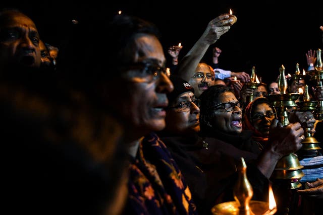 Activists hold a candlelight vigil to protest the ban on women