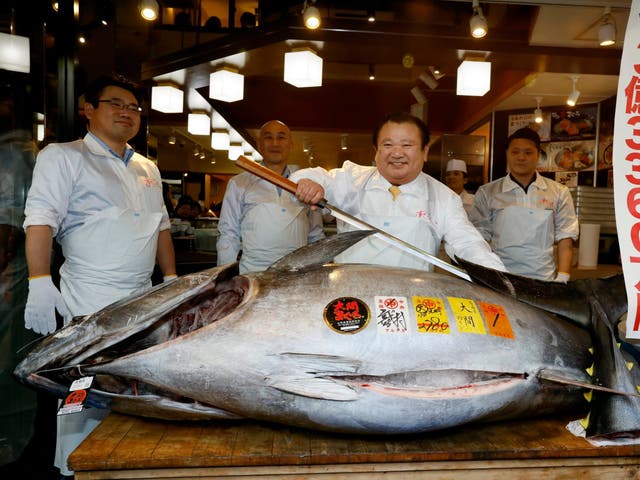 Kiyoshi Kimura (centre) stands over the huge bluefin tuna he bought for £2.5m