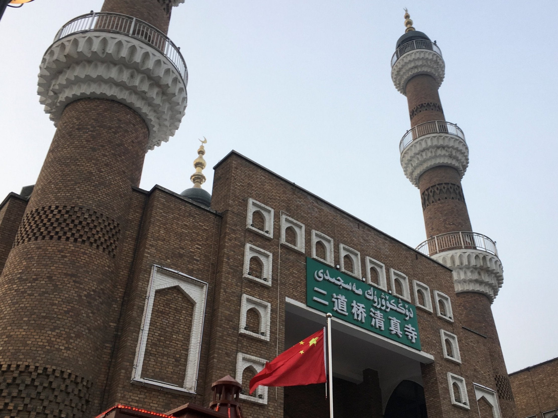 The Chinese national flag flies outside a mosque in Urumqi, Xinjiang