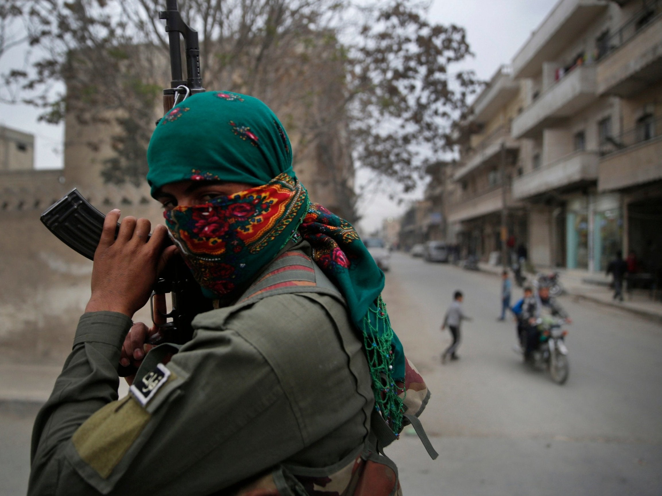 A member of the Kurdish internal security forces holds his weapon during a patrol in Manbij, north Syria