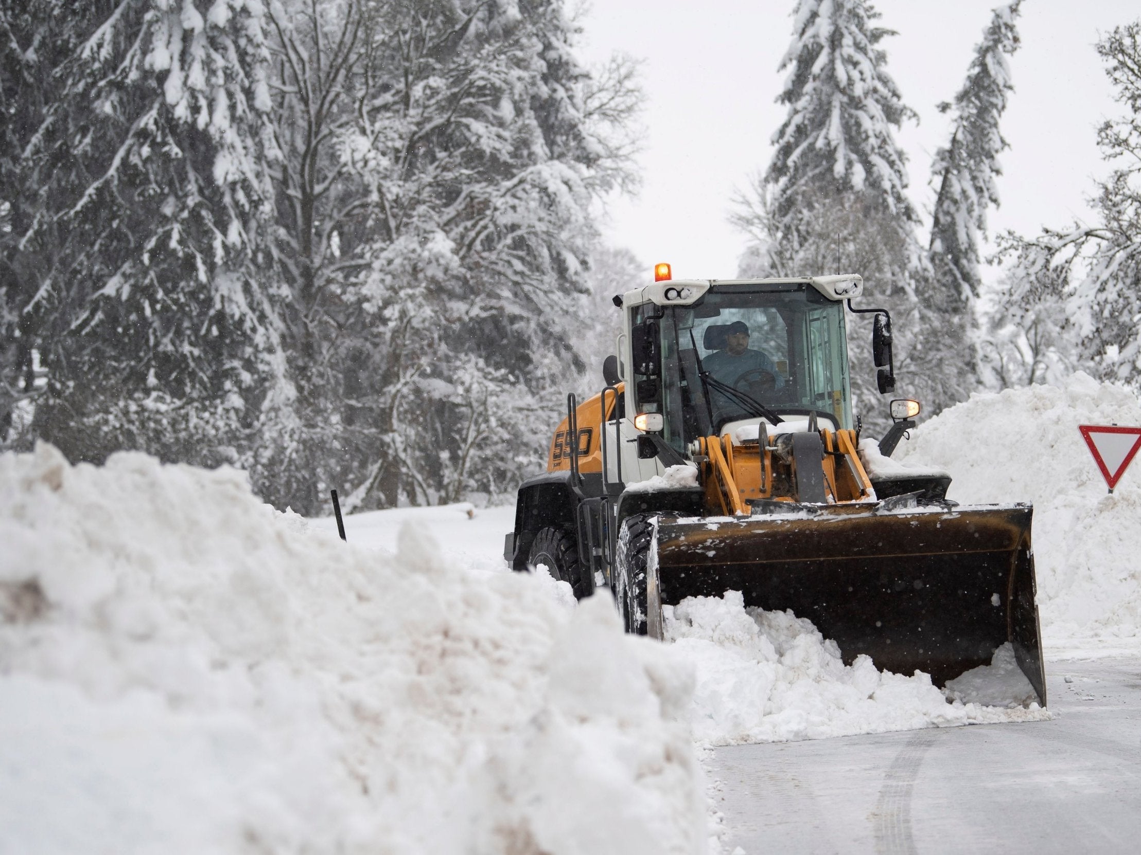 Workers clear snow near Holzkirchen, Bavaria, after heavy snowfalls over the weekend