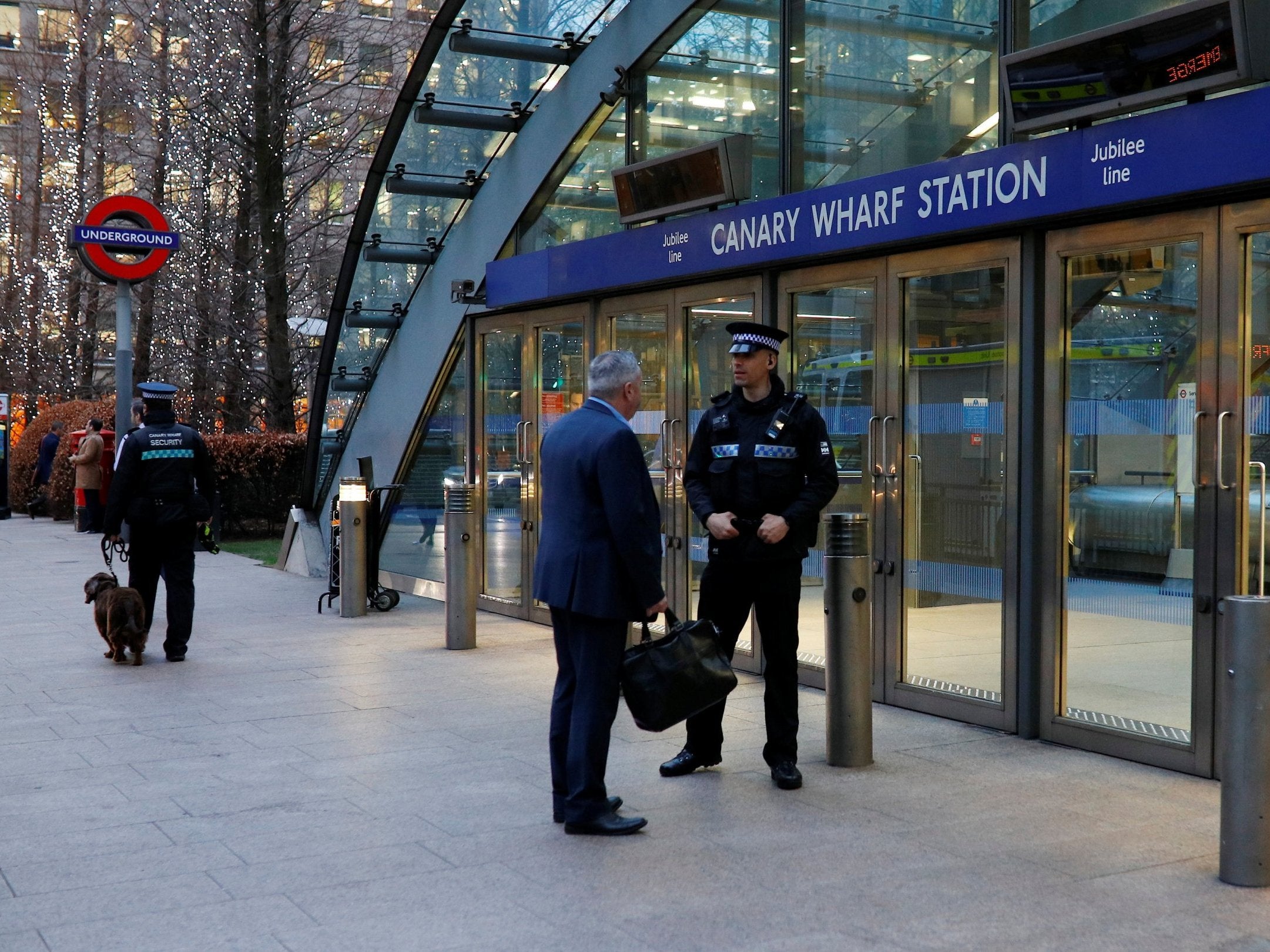 Security guards outside Canary Wharf tube station, which shut down following a fatal fall on the escalator