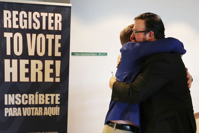 Lance Wissinger and Neil Volz hug after turning in their voter registration forms at the Lee County Supervisor of Elections office on 8 January 2019 in Fort Myers, Florida