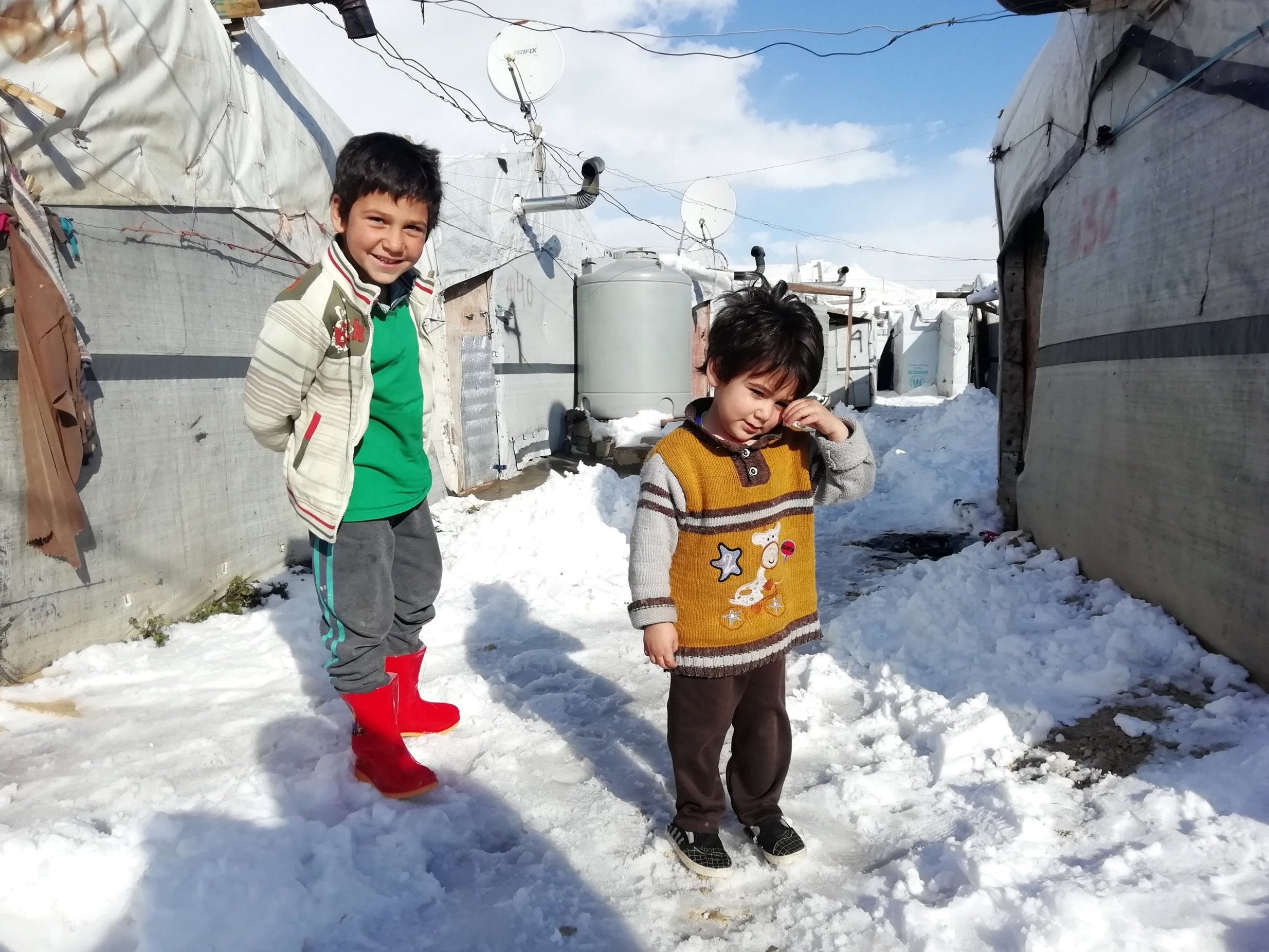 Syrian refugee children stand near tents at a makeshift camp at the Lebanese border town of Arsal, Lebanon, on Wednesday