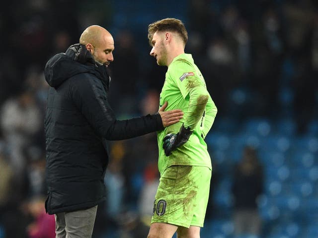 Pep Guardiola commiserates with Burton Albion goalkeeper Bradley Collins after Manchester City's 9-0 victory