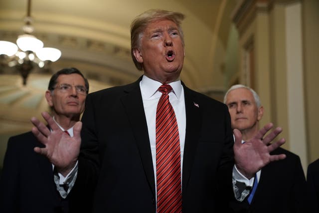 US President Donald Trump (2nd L) speaks to members of the media as Senator John Barrasso (R-WY) (L) and Vice President Mike Pence (R) listen