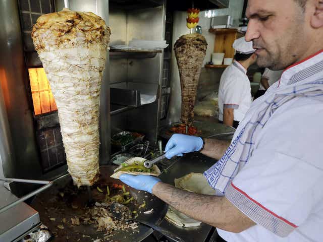 A chef wraps a chicken shawarma sandwich