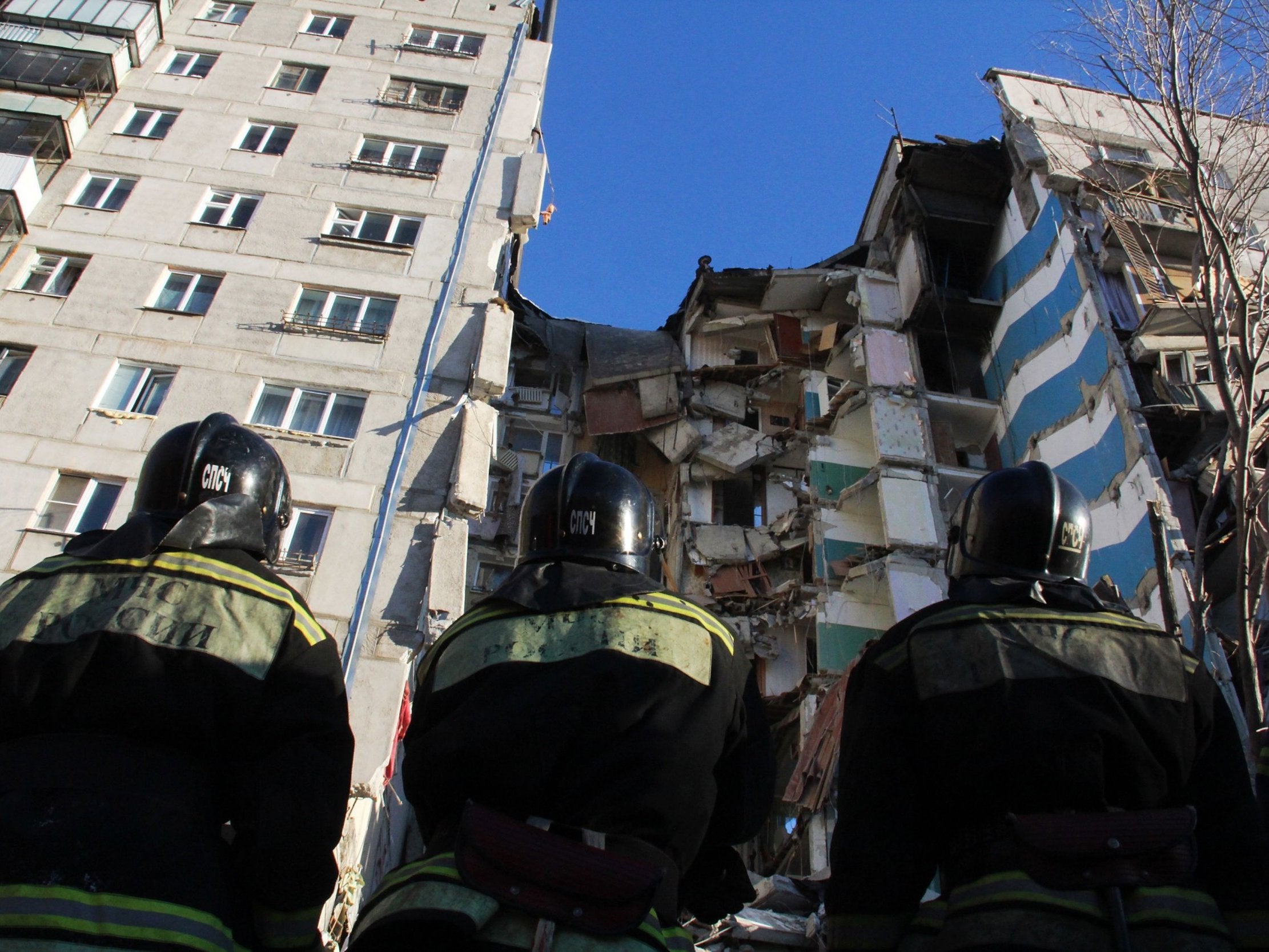 Firefighters stand during a rescue operation after a gas explosion rocked a residential building in Magnitogorsk on New Year’s eve