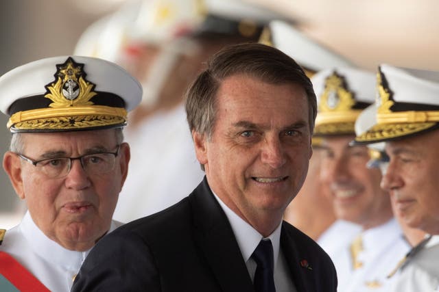 Brazilian President Jair Bolsonaro (C) arrives to participate in the Navy's change of command ceremony