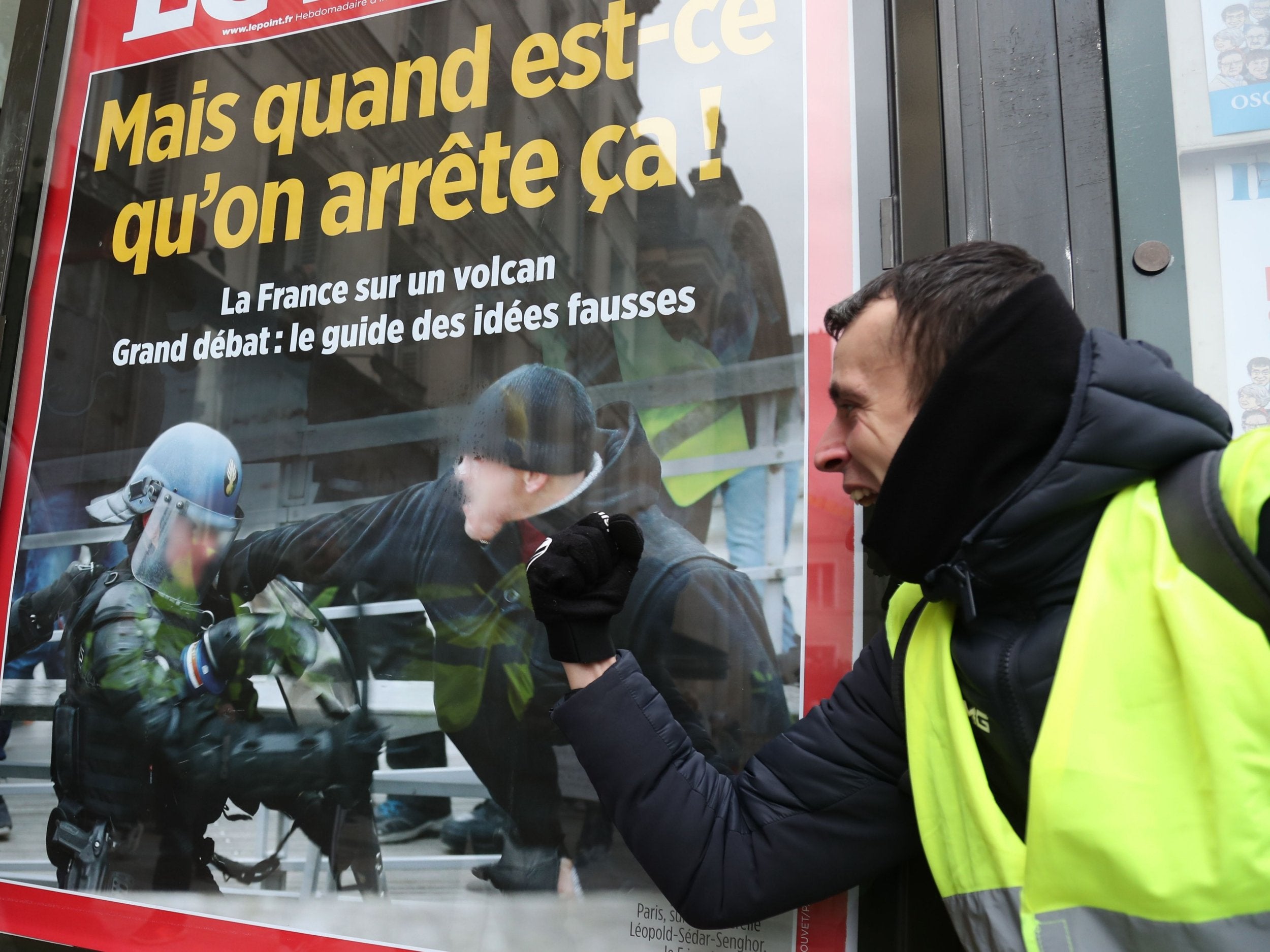 A protester poses next to the front page of a magazine depicting French boxer Christophe Dettinger who punched two French gendarmes last week, as he takes part in an anti-government demonstration called by the Yellow Vest "Gilets Jaunes" movement in Paris, on January 12, 2019. - France braced for a fresh round of "yellow vest" protests on January 12, 2019 across the country with the authorities vowing zero tolerance for violence after weekly scenes of rioting and vandalism in Paris and other cities over the past two months. (Photo by Zakaria ABDELKAFI / AFP)ZAKARIA ABDELKAFI/AFP/Getty Images