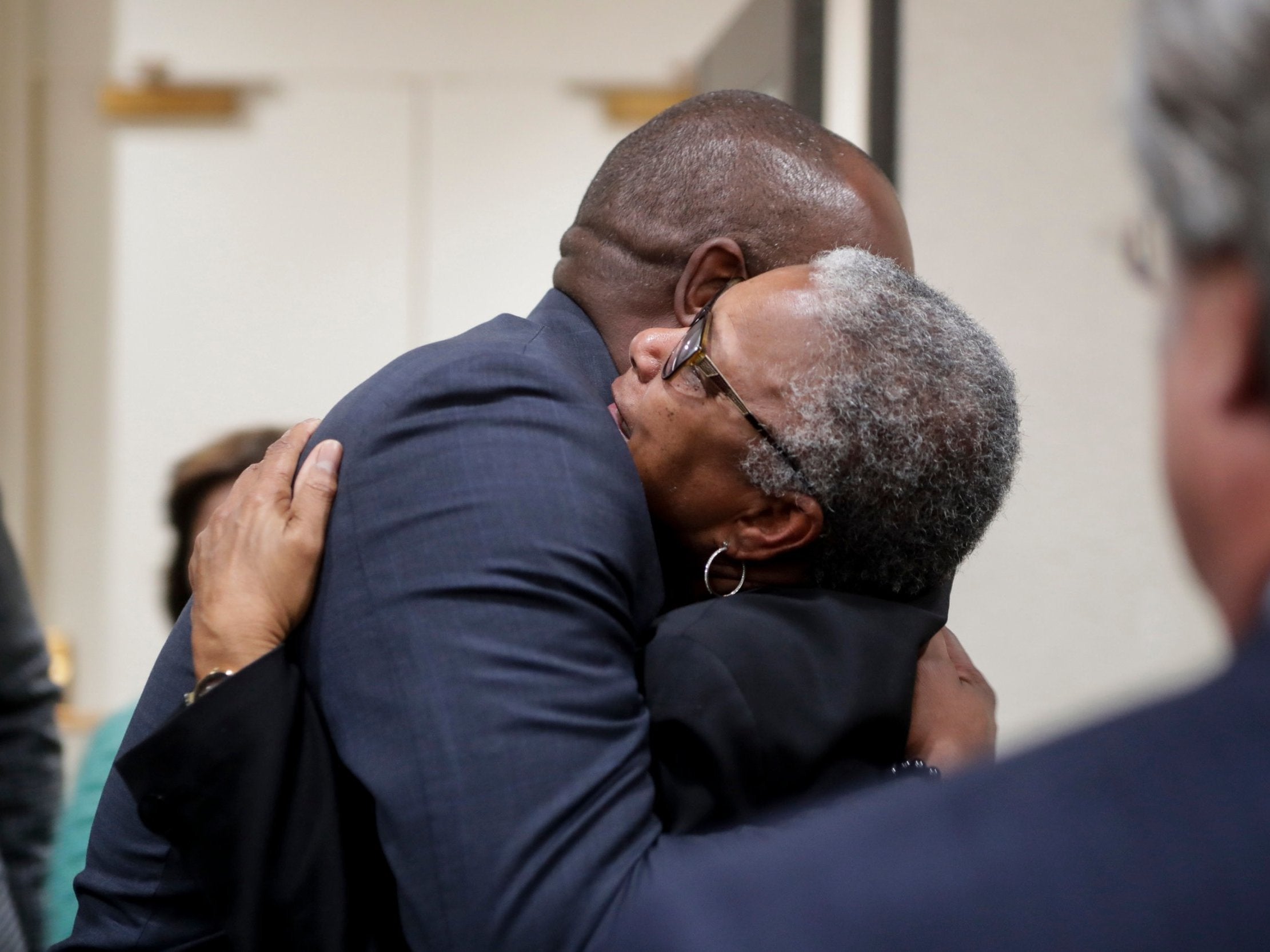 Carol Greenlee, daughter of Charles Greenlee, hugs Rep Bobby Dubose after her father was pardoned by Florida governor Ron DeSantis and his cabinet on Friday