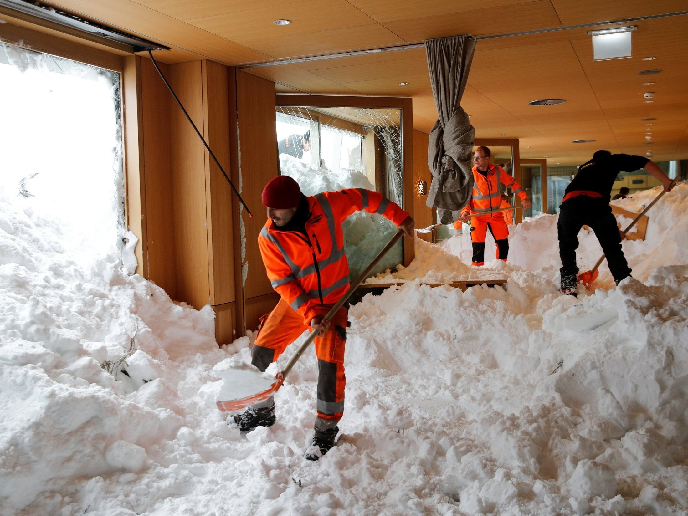 Workers shovel snow out of a hotel restaurant in the Santis-Schwaegalp mountain resort in in Switzerland