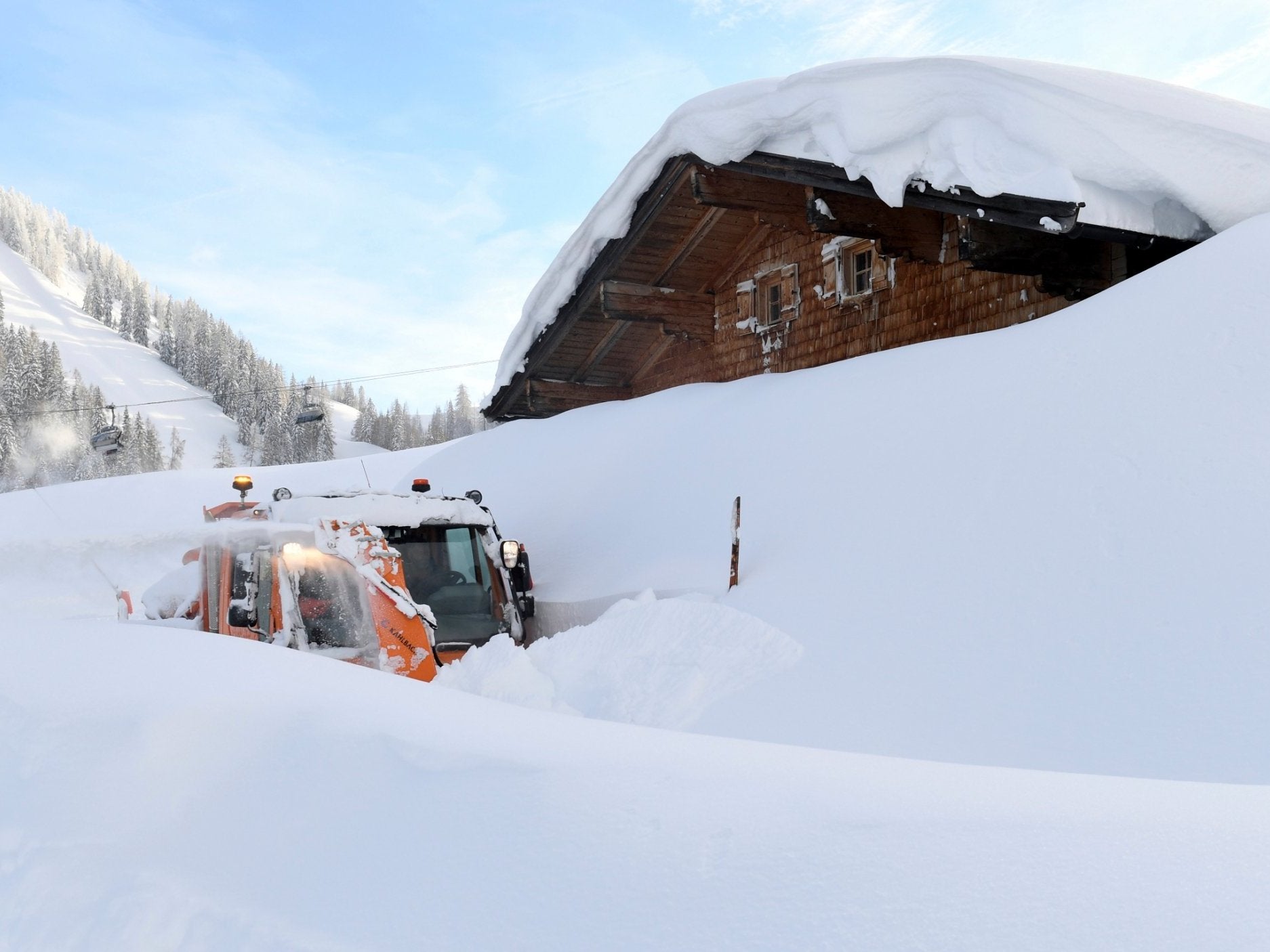 An excavator clears snows in the Austrian Alps