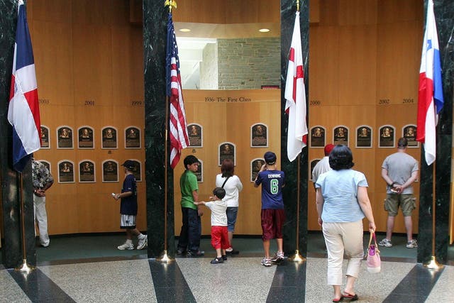Fans look at the plaques of players inducted into the National Baseball Hall of Fame and Museum in New York