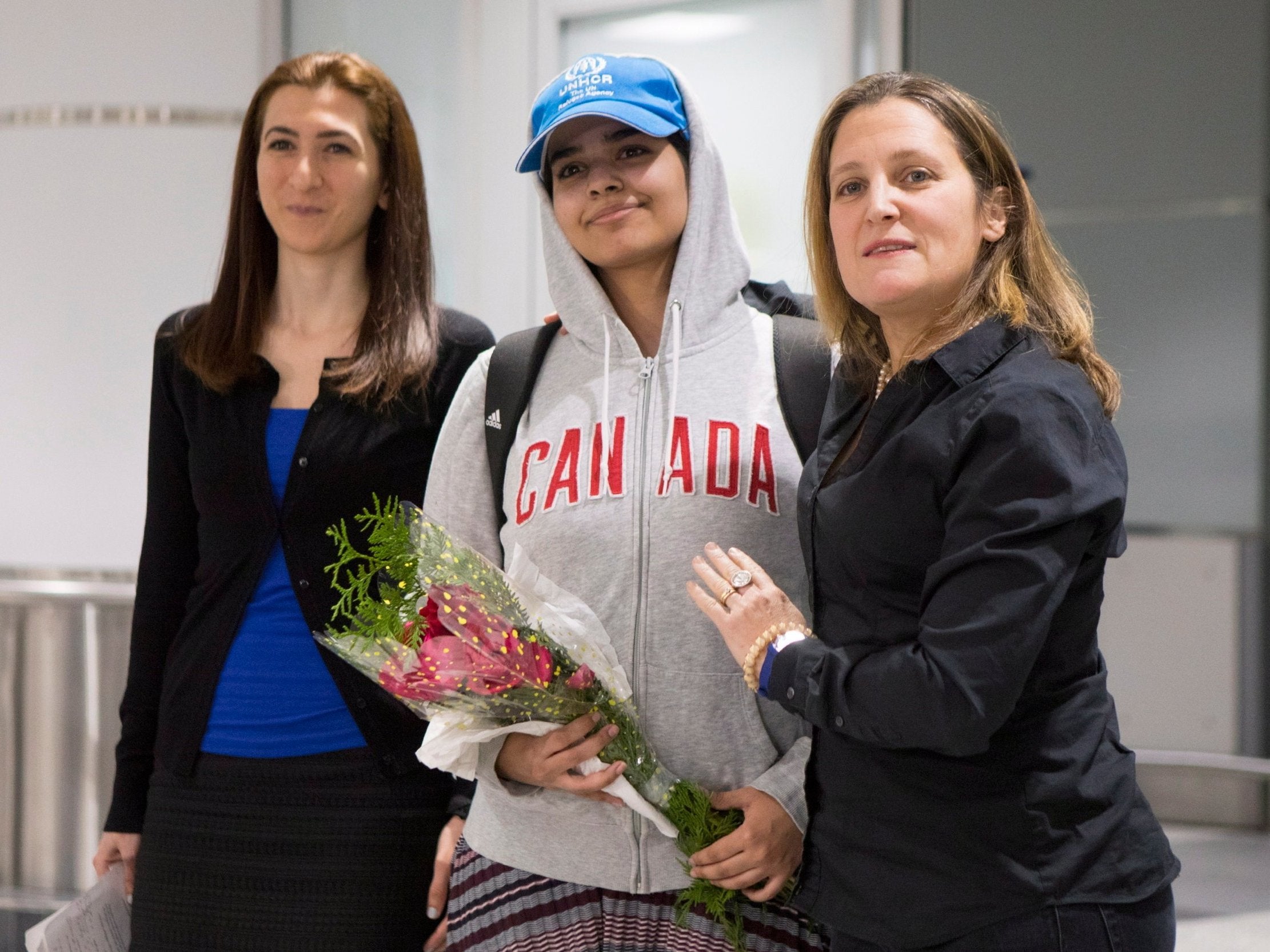 Rahaf Mohammed Alqunun, 18, centre, stands with Canadian Minister of Foreign Affairs Chrystia Freeland, right, as she arrives at Toronto Pearson International Airport, on Saturday 12 January 2019.