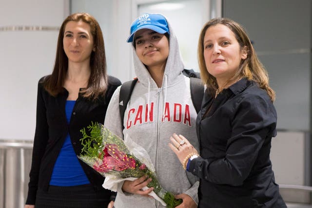 Rahaf Mohammed Alqunun, 18, centre, stands with Canadian Minister of Foreign Affairs Chrystia Freeland, right, as she arrives at Toronto Pearson International Airport, on Saturday 12 January 2019. 