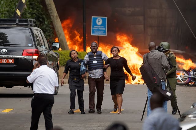 Security forces help civilians flee the scene at hotel complex in Nairobi