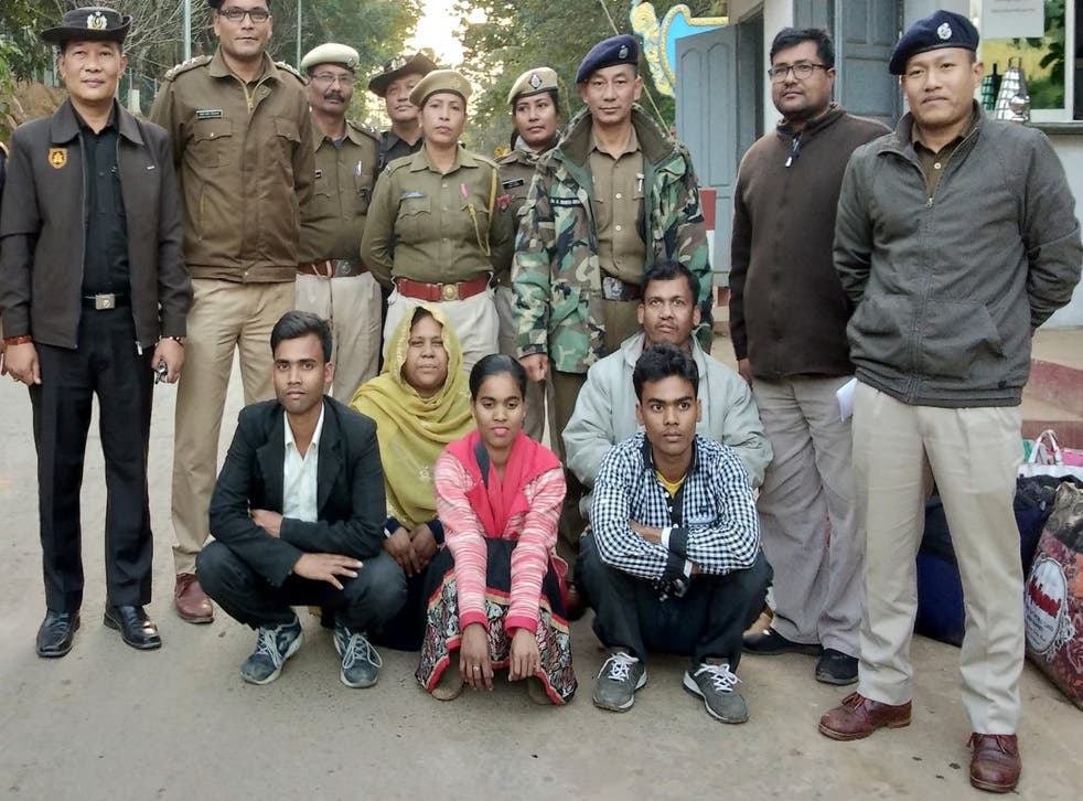 Members of a Muslim Rohingya family sit as they pose for a photograph with Indian and Myanmar security officials before their deportation on the India-Myanmar border at Moreh, in the northeastern state of Manipur, India on 3 January 2019.