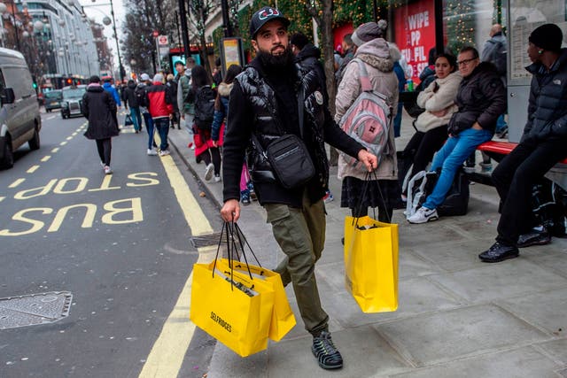 A shopper carries bags of goods bought in the Boxing Day sale in London